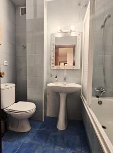 une salle de bains avec lavabo, toilettes et miroir dans l'établissement Apartamento LOS BALCONES DE BARBATE, à Barbate