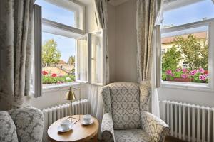 Habitación con 2 sillas, mesa y 2 ventanas en Hotel At the Golden Scissors, en Praga