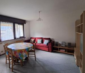 ein Wohnzimmer mit einem roten Sofa und einem Tisch in der Unterkunft casa palma in Levico Terme