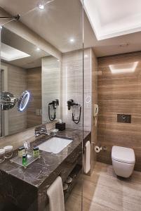 een badkamer met een wastafel en een glazen douche bij Park Dedeman Bostanci Hotel in Istanbul