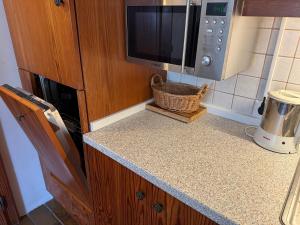 una cucina con piano di lavoro, forno a microonde e bancone sidx sidx di Ski in & Ski out Apartment at Chalet Heinrich a Sonnenalpe Nassfeld Altre 32 foto