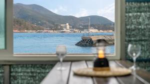 a table with two wine glasses and a view of the water at tongyeong haegando pension in Tongyeong +4 photos