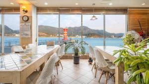 a dining room with tables and chairs and a lighthouse at tongyeong haegando pension in Tongyeong