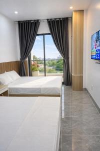 Un dormitorio con una cama y una ventana grande. en Hải Nam Homestay Cam Lâm, en Cam Lâm