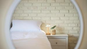 a bedroom with a white brick wall and a bed at tongyeong haegando pension in Tongyeong
