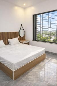 Un dormitorio con una cama grande y una ventana grande. en Hải Nam Homestay Cam Lâm, en Cam Lâm