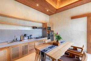 a kitchen with a wooden table and a sink at Weda Villas in Ubud