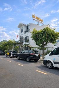 Un estacionamiento con autos estacionados frente a un edificio. en Hải Nam Homestay Cam Lâm, en Cam Lâm