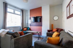 een woonkamer met twee banken en een tv bij Beaconsfield Stay Family & Work Friendly in Darlington