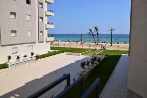 a view of the beach from the balcony of a building at Fantastic Appartment SeaView Sousse in Akouda