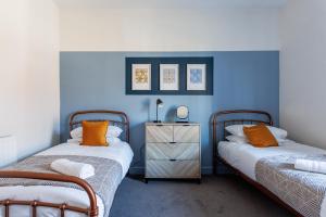 twee bedden in een kamer met blauwe muren bij Beaconsfield Stay Family & Work Friendly in Darlington