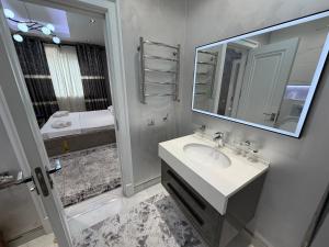 een badkamer met een wastafel en een spiegel bij Tashkent City Apartments 1A in Tasjkent +18 foto's