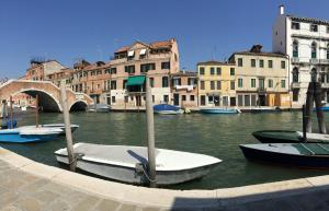 a group of boats in a canal with buildings at Princess Guest House Canal View in Venice