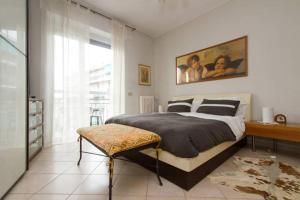 Un dormitorio con una cama y un escritorio y una ventana. en Angelica House, en Milán