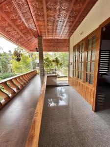 a room with a wooden floor and a wooden ceiling at Avocado Orchards - Home Stay in Kenichira +3 photos