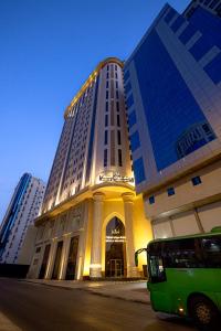 um autocarro estacionado em frente a um edifício alto em فندق ميزاب السابق 2 em Meca