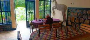 a man sitting at a table in a restaurant at Small Land Home Stay in Kibuye