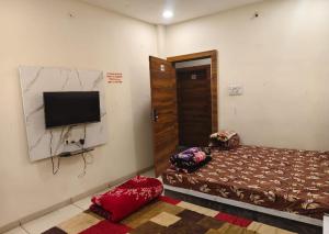 a bedroom with a bed and a flat screen tv at Hotel M S in Pālia