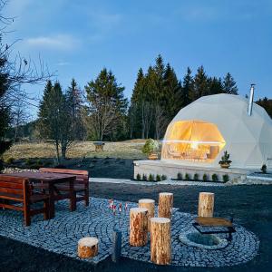een grote koepeltent met een vuurplaats in een park bij Glamping Geodome Horní Blatná in Horní Blatná