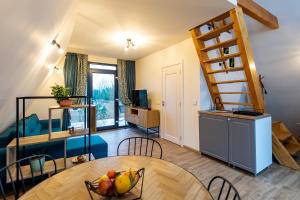 a room with a table and a kitchen with a spiral staircase at A-frame Dor De Aer in Herneacova
