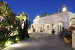 a white building with palm trees and lights at La Bella Trani - Suites and B&B in Trani