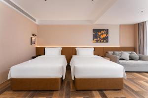 Giường trong phòng chung tại Meihou Lizhi Hotel Qingdao May Fourth Square MixC Branch +19 ảnh