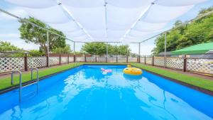 een buitenzwembad met een opblaasbaar badspeeltje en een opblaasbaar vlot bij Daebudo green beach Pension in Ansan +15 foto's