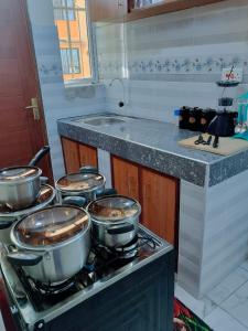 een keuken met verschillende potten en pannen op een fornuis bij Mwangaza in Mombasa