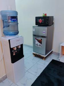 een keuken met een watertank en een koelkast bij Mwangaza in Mombasa