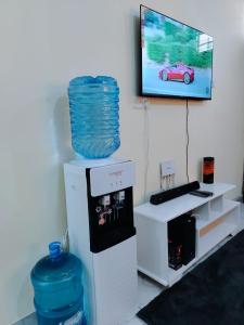 een kamer met een tv aan de muur en een waterreservoir bij Mwangaza in Mombasa