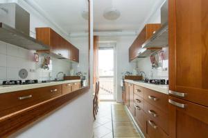cocina grande con armarios de madera y ventana en Angelica House, en Milán