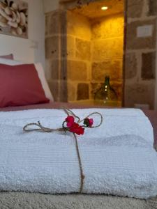 een wit bed met een rode bloem erop bij Casa Ninu' in Maruggio +45 foto's