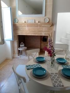 een eetkamer met een tafel en een open haard bij Casa Ninu' in Maruggio