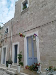 een gebouw met bloemenmanden aan de zijkant bij Casa Ninu' in Maruggio