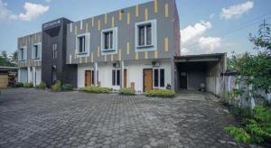 ein großes Gebäude mit einem Innenhof davor in der Unterkunft Hotel O Green Palm Kostel Syariah in Tabahpingin