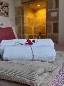 een stapel handdoeken met een bloem erop bij Casa Ninu' in Maruggio