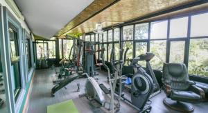 a gym with several exercise equipment in a room with windows at OYO 1140 Piyapruk Resort at Khaoyai in Ban Khanong Phra Klang (1)