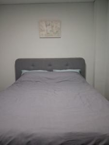 un letto in una camera da letto con un quadro sul muro di Книжка a Vinnycja