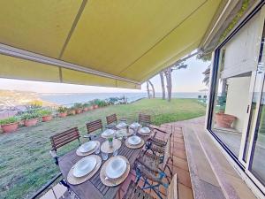 - une table et des chaises sur une terrasse couverte offrant une vue sur l'océan dans l'établissement Premium Habitat Les Villes, à Arenys de Mar