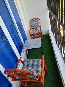 Twee stoelen en een tafel op een balkon met gras. bij Tausi Home in Mombasa