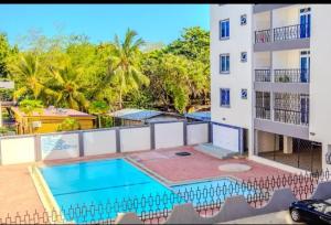 uitzicht vanaf het balkon van een gebouw met een zwembad bij Tausi Home in Mombasa