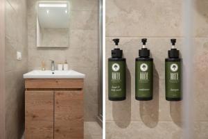 Luxury Kingbed Studio - Estia Premium Apartments في سلانيك: حمام معلق على الحائط زجاجتان من جلايد