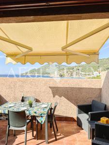 un patio con tavolo e sedie e una grande finestra di Fortuna a Campese