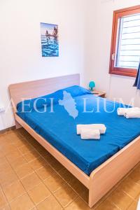 una camera da letto con letto con lenzuola e asciugamani blu di Fortuna a Campese