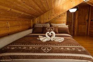 Una cama con dos toallas en una cabaña en Maso Patrizia - Il tuo rifugio nella natura, en Pieve Tesino