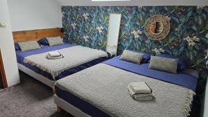 een kamer met 2 bedden en een muur met bloemen bij Domaine Dorimar in Saint-Just-en Brie +12 foto's