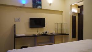 a room with a bed and a tv on a wall at Neel Farms and Resort in Saoner