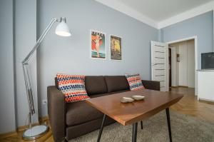 ein Wohnzimmer mit einem Sofa und einem Tisch in der Unterkunft SmileApartment Partyzantów in Gdynia