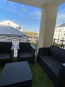een balkon met twee banken en uitzicht op een gebouw bij Douillet BY DREAM APARTMENTS in Serris
