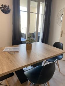 een grote houten tafel met stoelen en een plant erop bij Douillet BY DREAM APARTMENTS in Serris +10 foto's